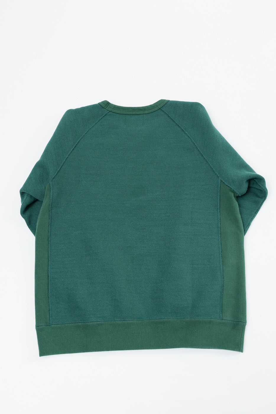Back view flat lay of a dark green raglan sleeve sweatshirt with a ribbed hem.