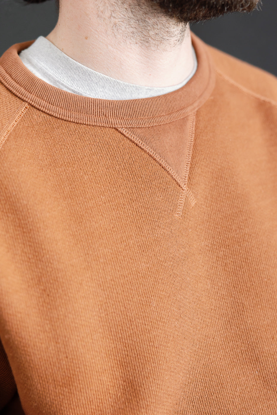 Close-up of men's Wonder Looper rust crewneck pullover, front collar and fabric detail.