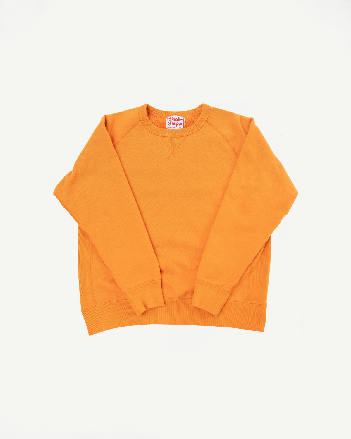 Front view of orange crewneck sweatshirt with ribbed cuffs and hem, featuring a visible brand tag.