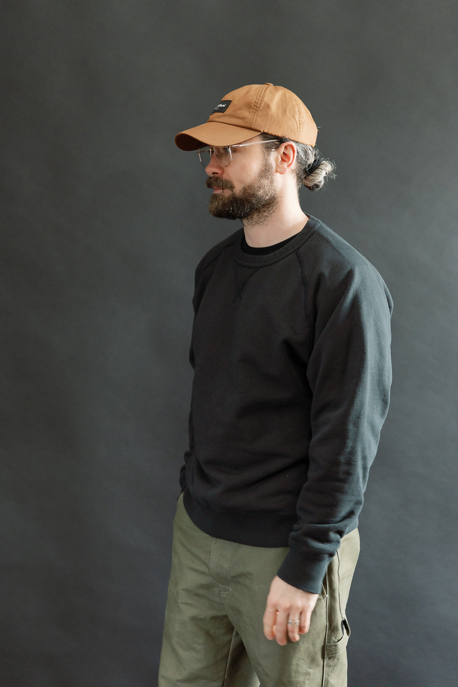 Pullover Crewneck - Super Looper French Terry - Sumi, shown on a side-profile view of a casually dressed man with a beard, highlighting the unique textured fabric and modern athletic fit.
