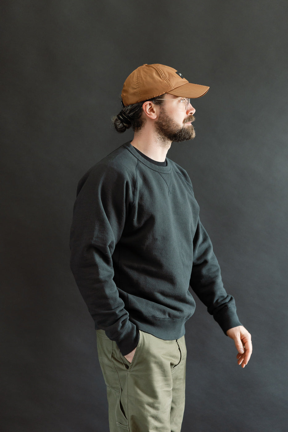 Pullover Crewneck - Super Looper French Terry - Sumi showcased in profile, featuring a modern athletic fit with raglan sleeves and a distinct textured surface, worn by a model in a minimalist setting.