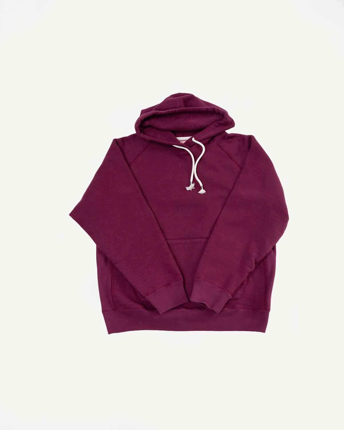 Front view flat lay of a maroon hooded sweatshirt with white drawstrings.