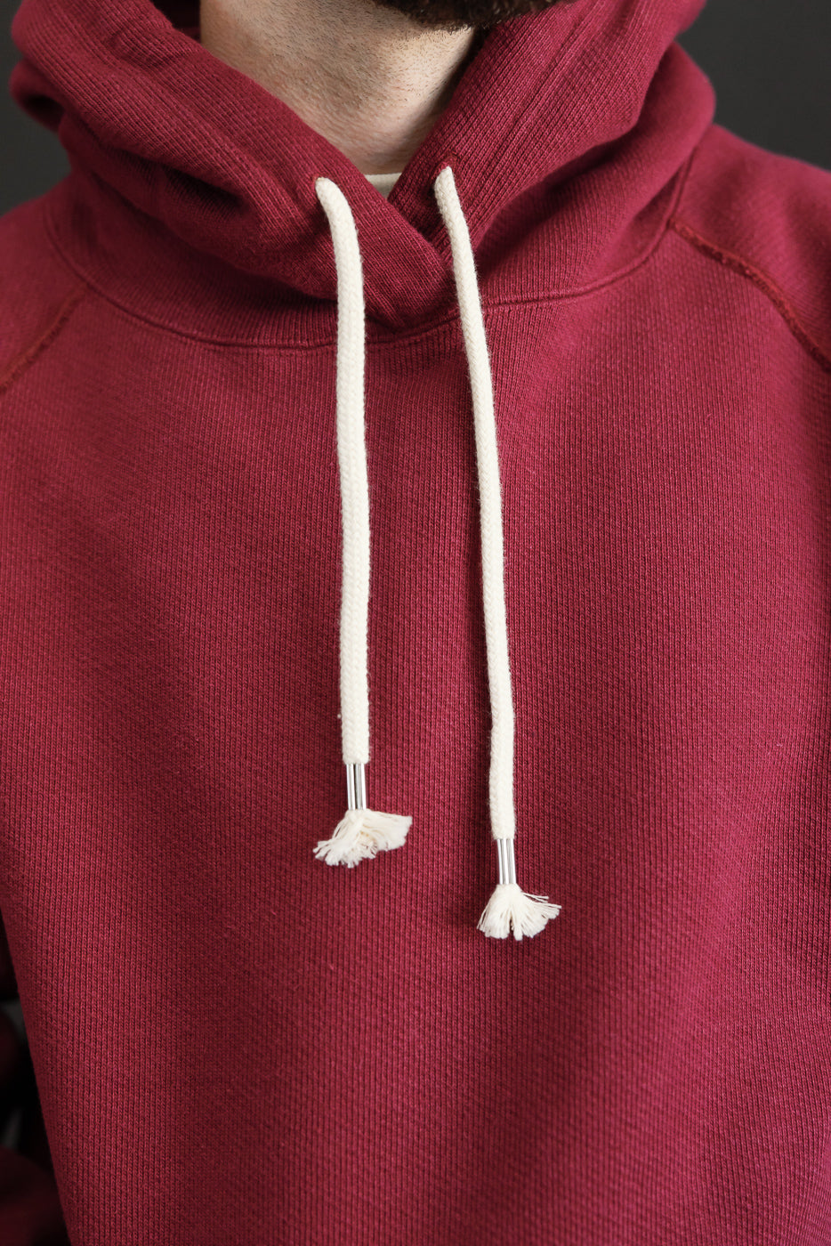 Close-up front view of a maroon hoodie on a 5'9