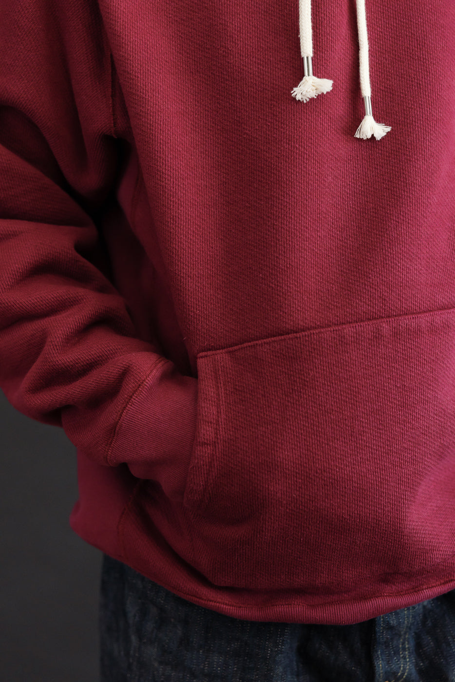 Close-up front view of a maroon hoodie on a 5'9