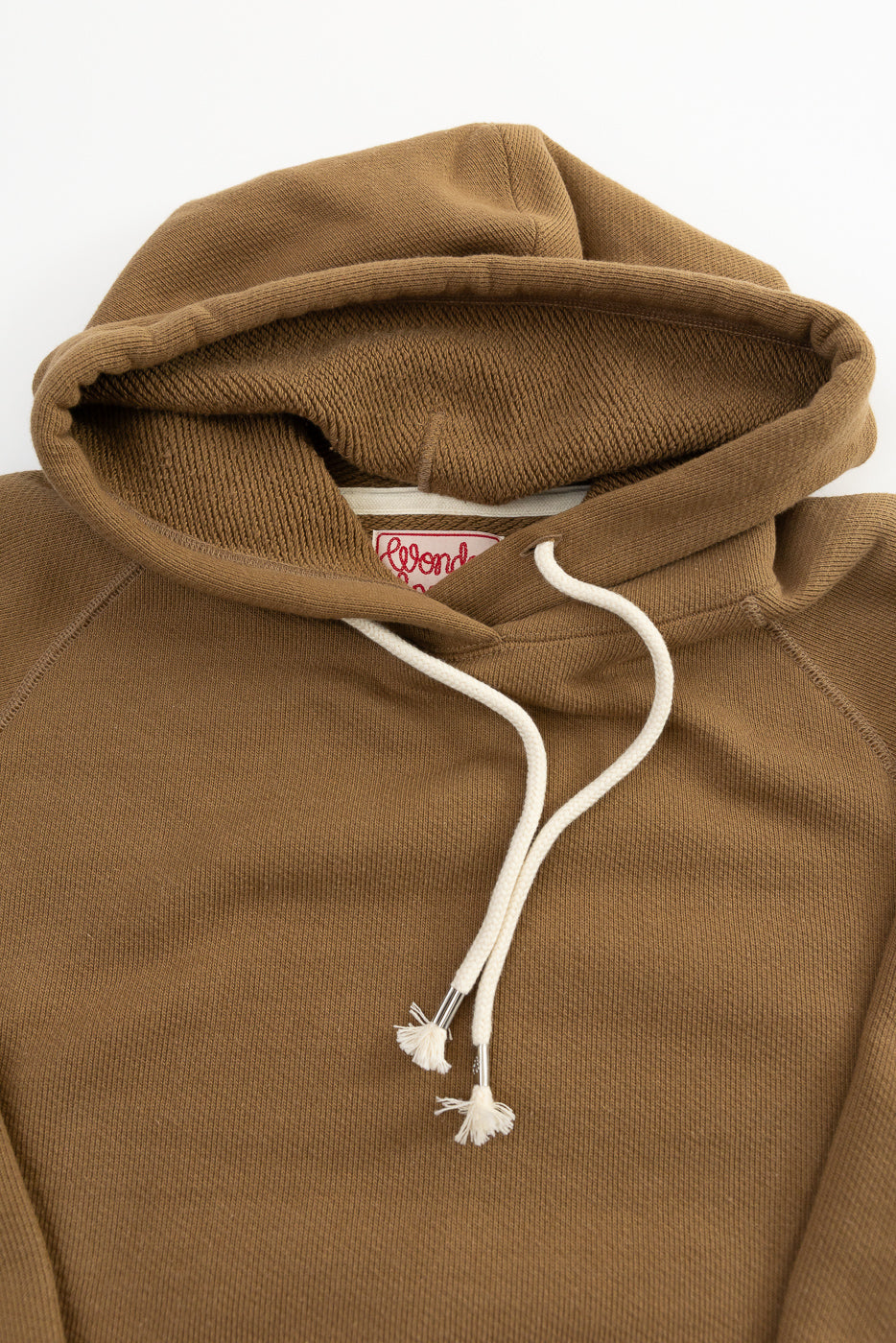 Close-up of Wonder Looper pullover hoodie front, dune brown French terry, hood and drawstrings visible