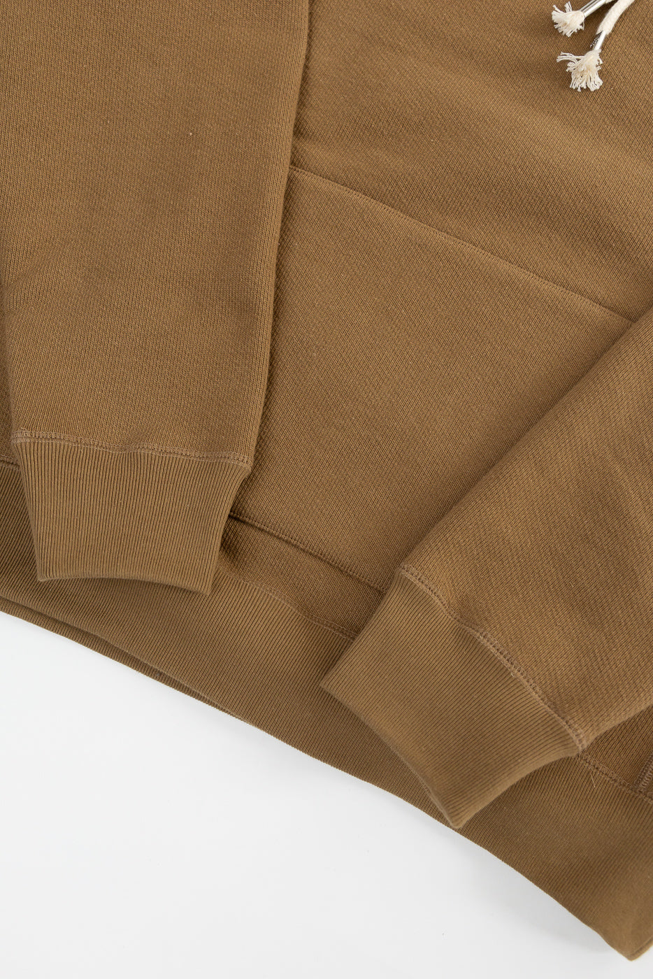 Close-up of Dant Wonder Looper pullover hoodie front hem, sleeve cuffs, heavyweight French terry fabric in dune color.