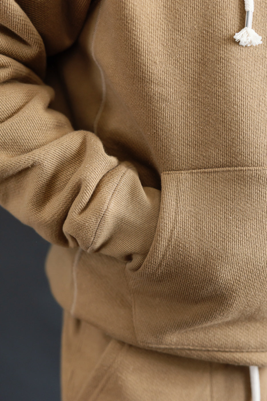 Close-up of front pocket and sleeve on Dant Wonder Looper pullover hoodie in dune, heavyweight French terry fabric.