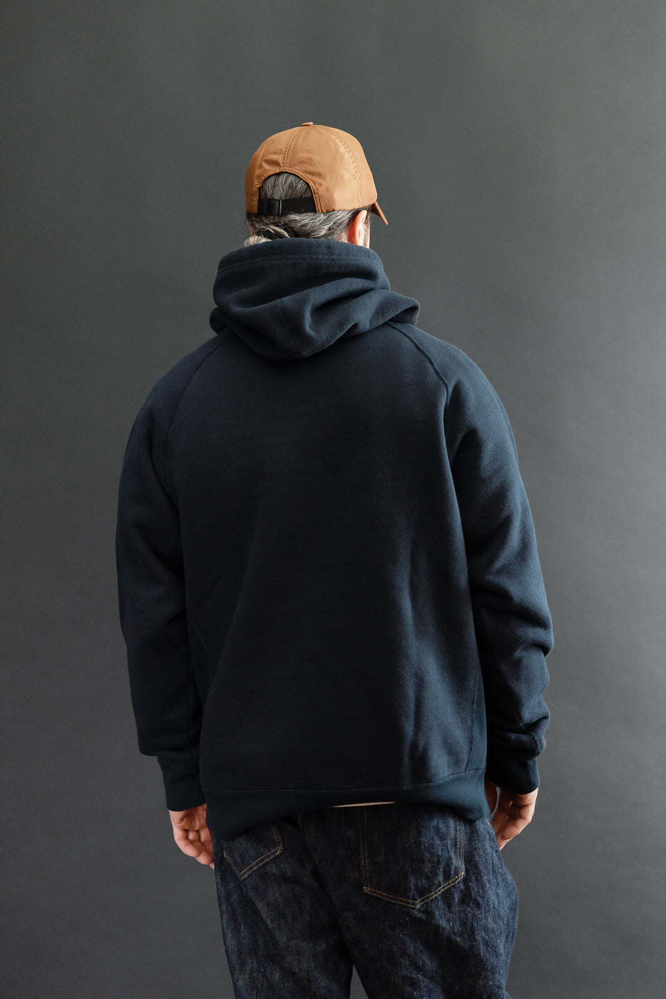 Back view of a navy blue hoodie on a 5'9