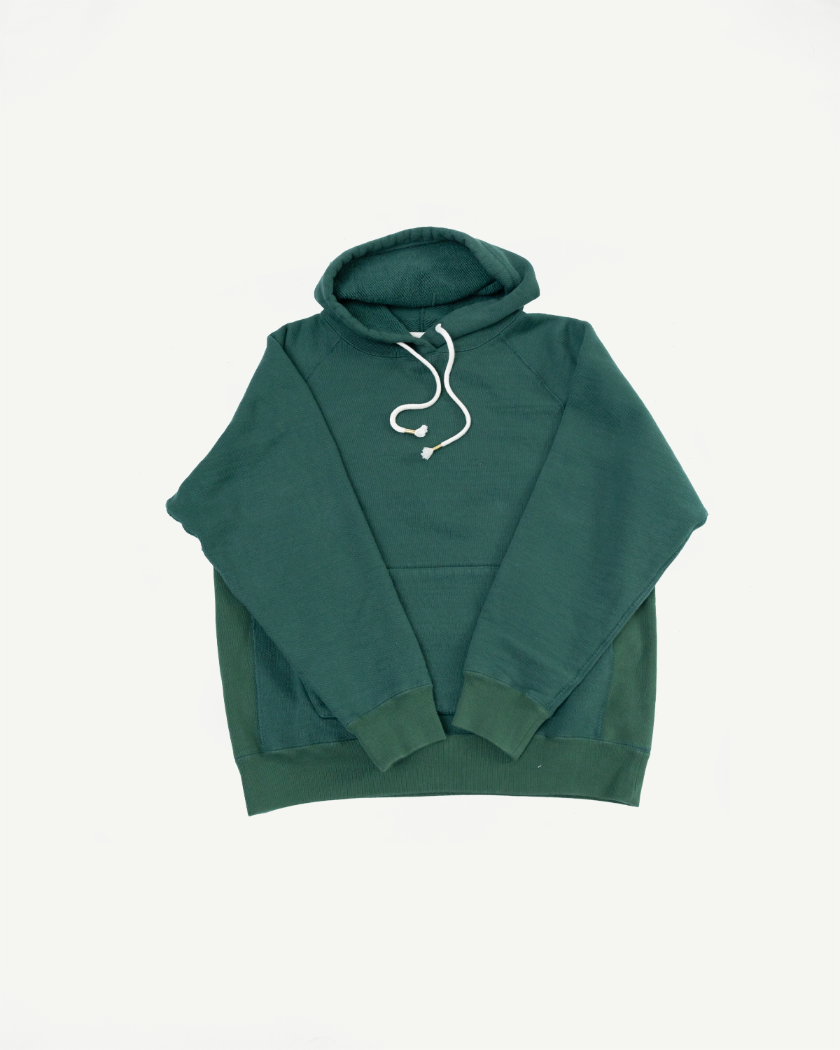 Front view flat lay of a dark green hooded sweatshirt with a contrasting green lower panel.