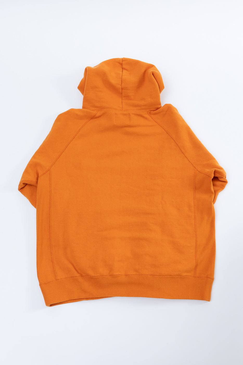 Pullover Hoodie - Super Looper French Terry - Orange, featuring a smooth exterior and raglan sleeves, laid flat to reveal the back view with a ribbed hem and hood on a white background.