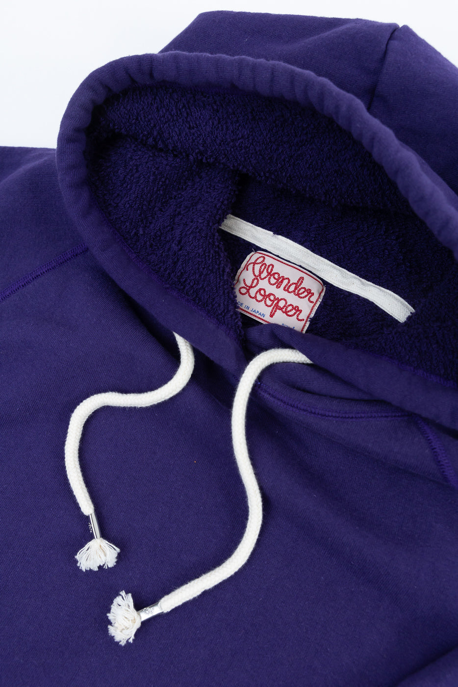 Purple hooded sweatshirt, Pullover Hoodie - Super Looper French Terry by Wonder Looper, with a soft loop-back terry interior, frayed white drawstring, and sewn-in label reading “Made in Japan.”