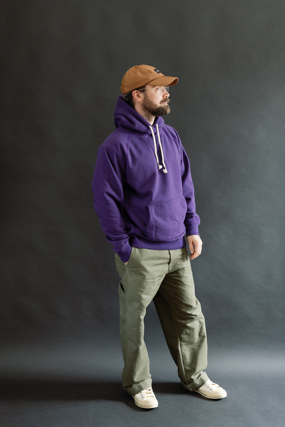Model wearing the Pullover Hoodie - Super Looper French Terry - Purple, featuring a plush, textured interior and smooth exterior, paired with olive trousers and light sneakers, embodying Dant's premium menswear style.
