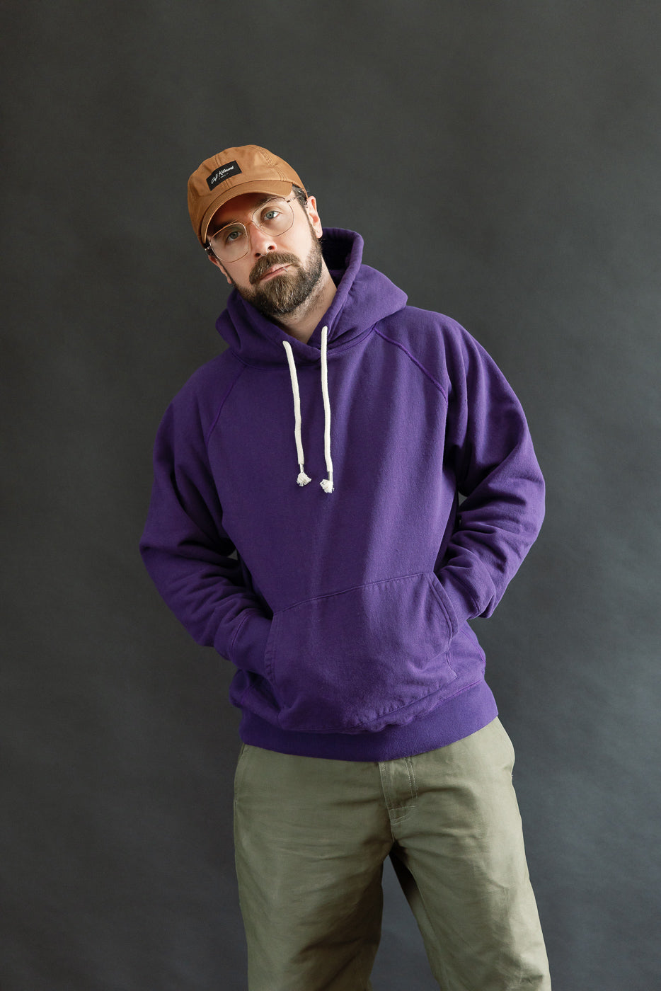 Pullover Hoodie - Super Looper French Terry - Purple, worn by a 5'9 male model, showcasing its smooth exterior and athletic fit with raglan sleeves and kangaroo pocket against a plain backdrop.
