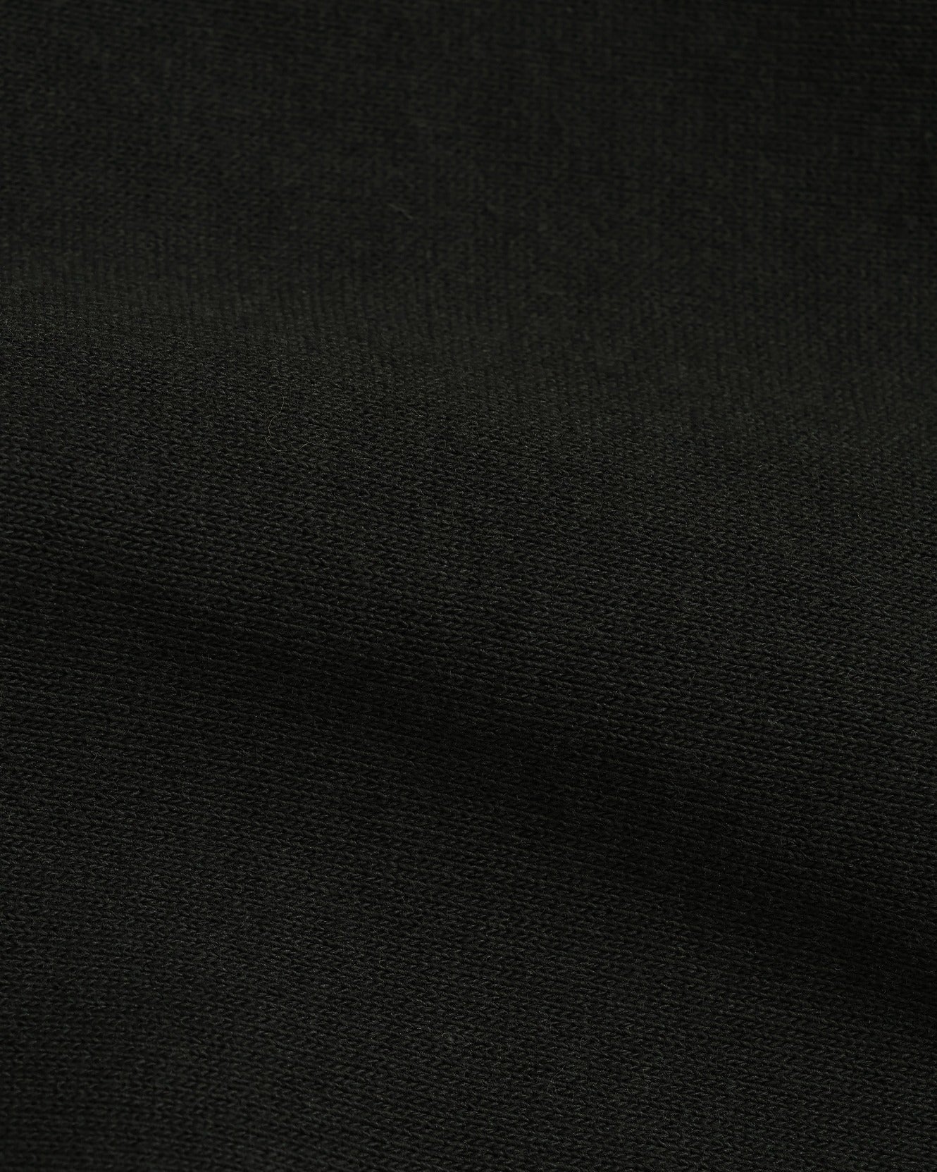 Close-up of black French terry hoodie fabric, highlighting texture and weave detail.