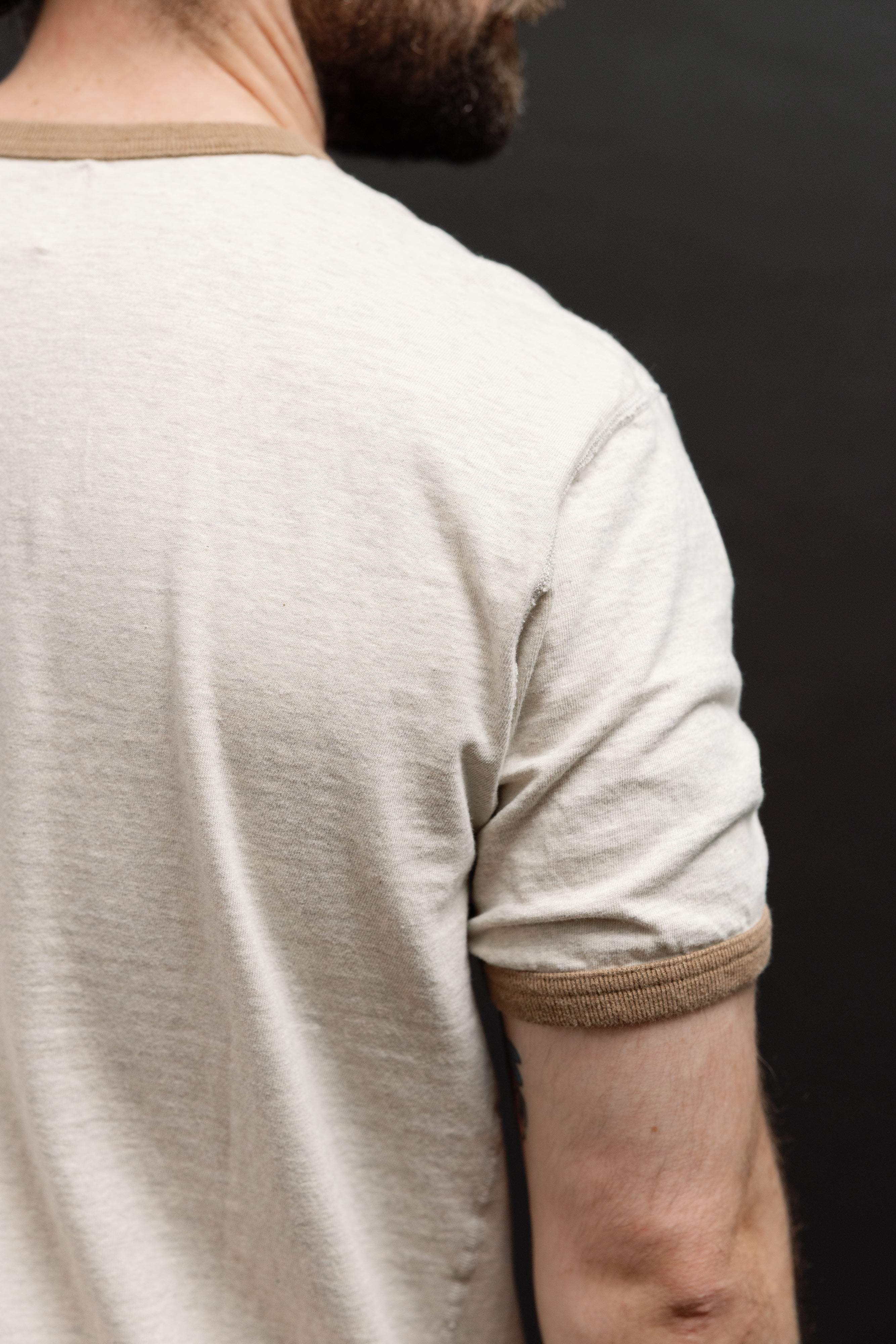 Close-up back view of a cream t-shirt on a 5'9