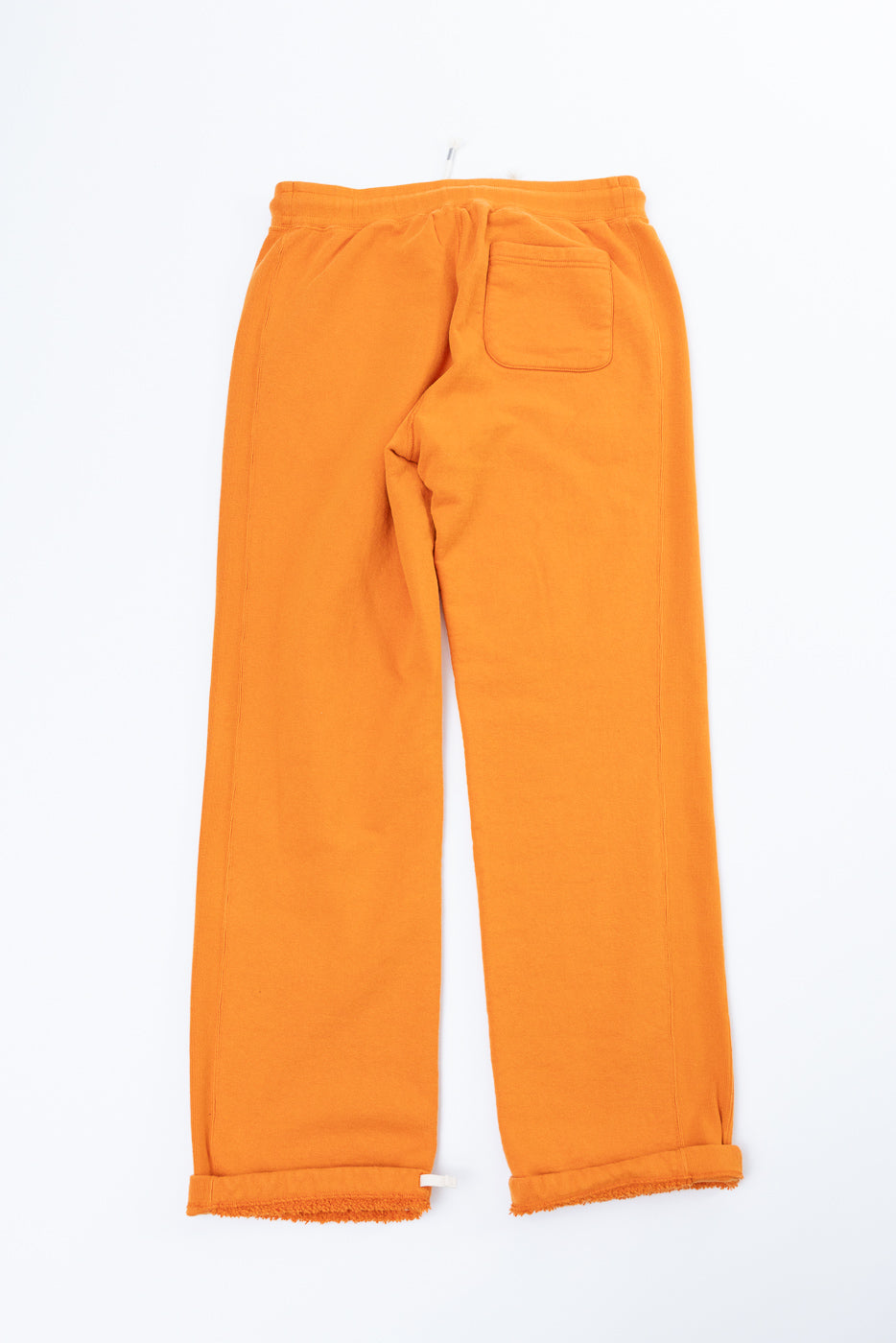 Back view of orange wide-leg sweatpants with cuffed hems, back pocket, and drawstring waist, flat lay