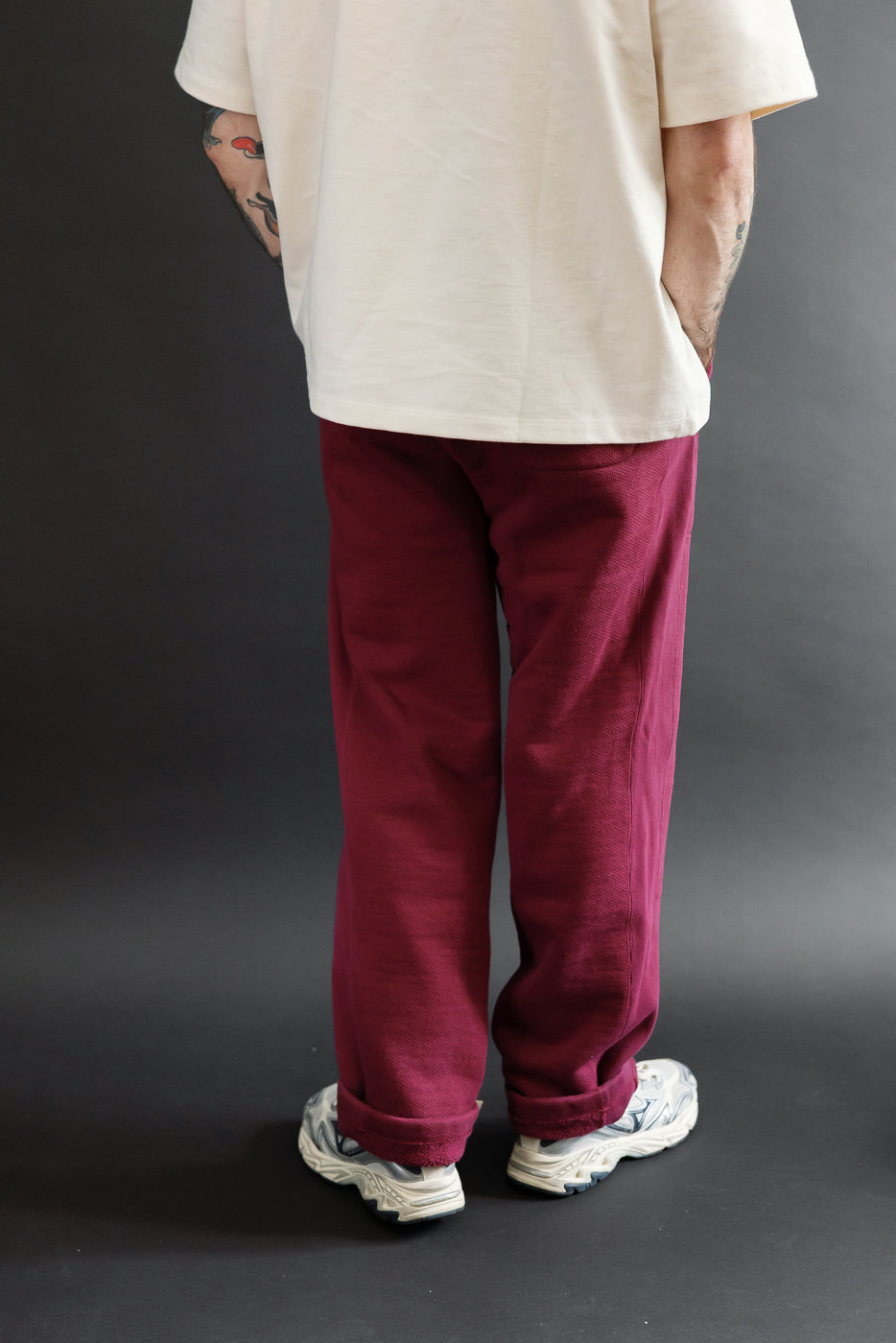 Back view of burgundy trousers on a male model, 5'9