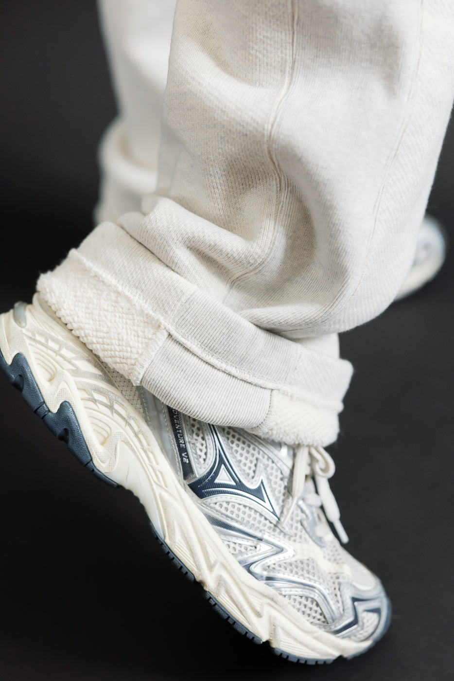 Close-up of the bottom hem and white sneakers worn by a male model.
