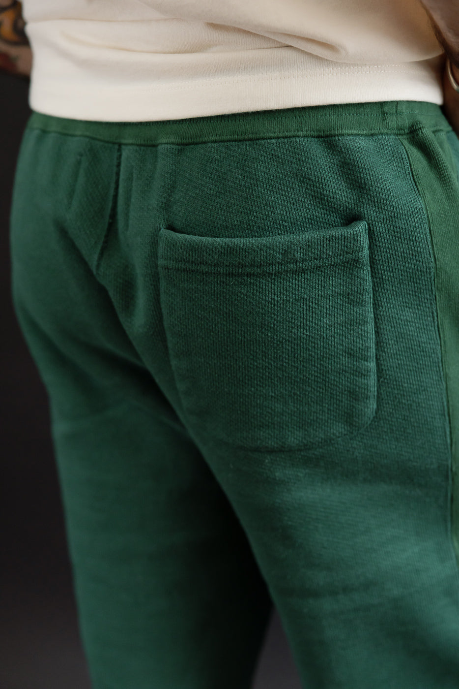 Close-up of back right pocket on green textured sweatpants; male model, 5'9