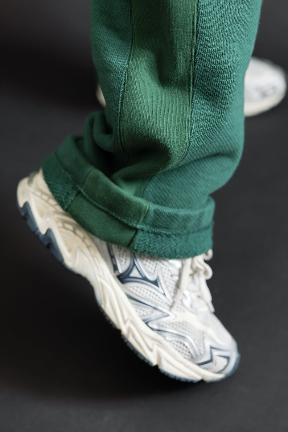 Close-up of green pants cuff and sneakers on male model, 5'9