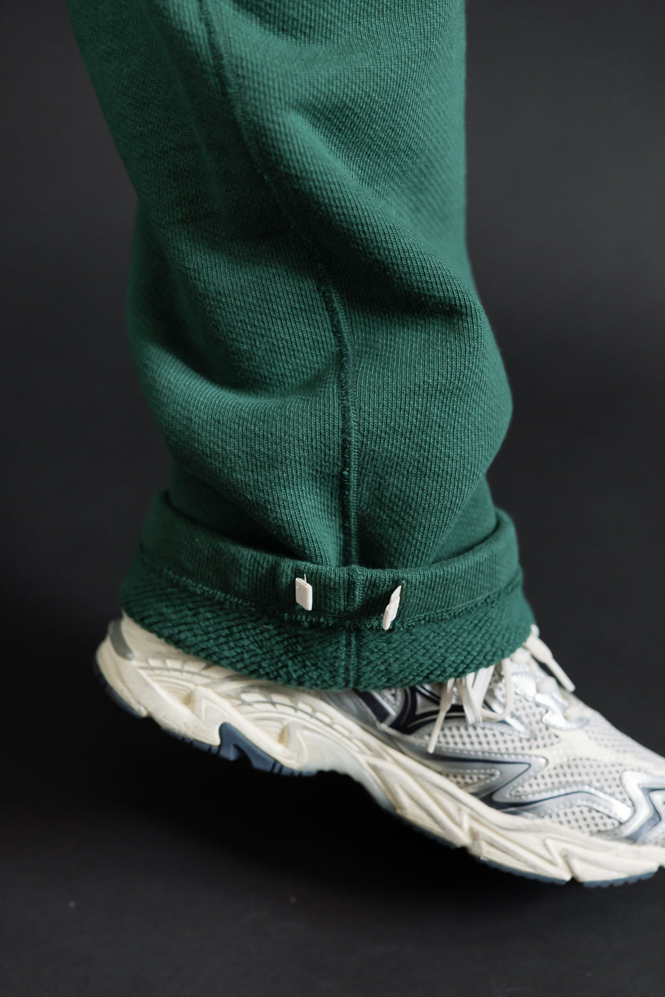 Close-up of cuffed hem on green trousers worn by a 5'9