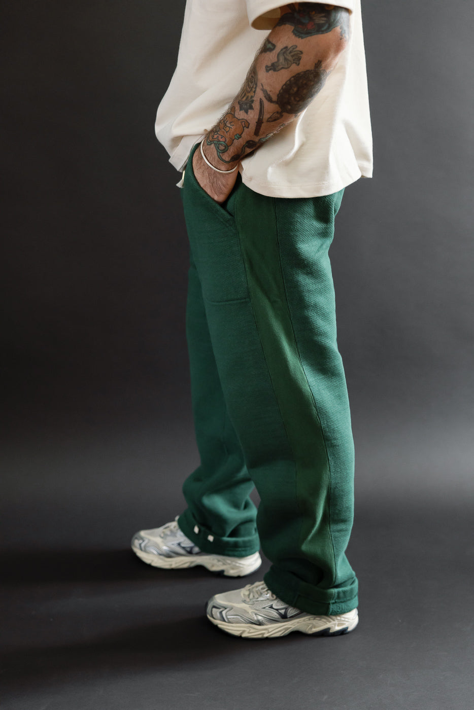 Side view of green sweatpants on a male model (5'9