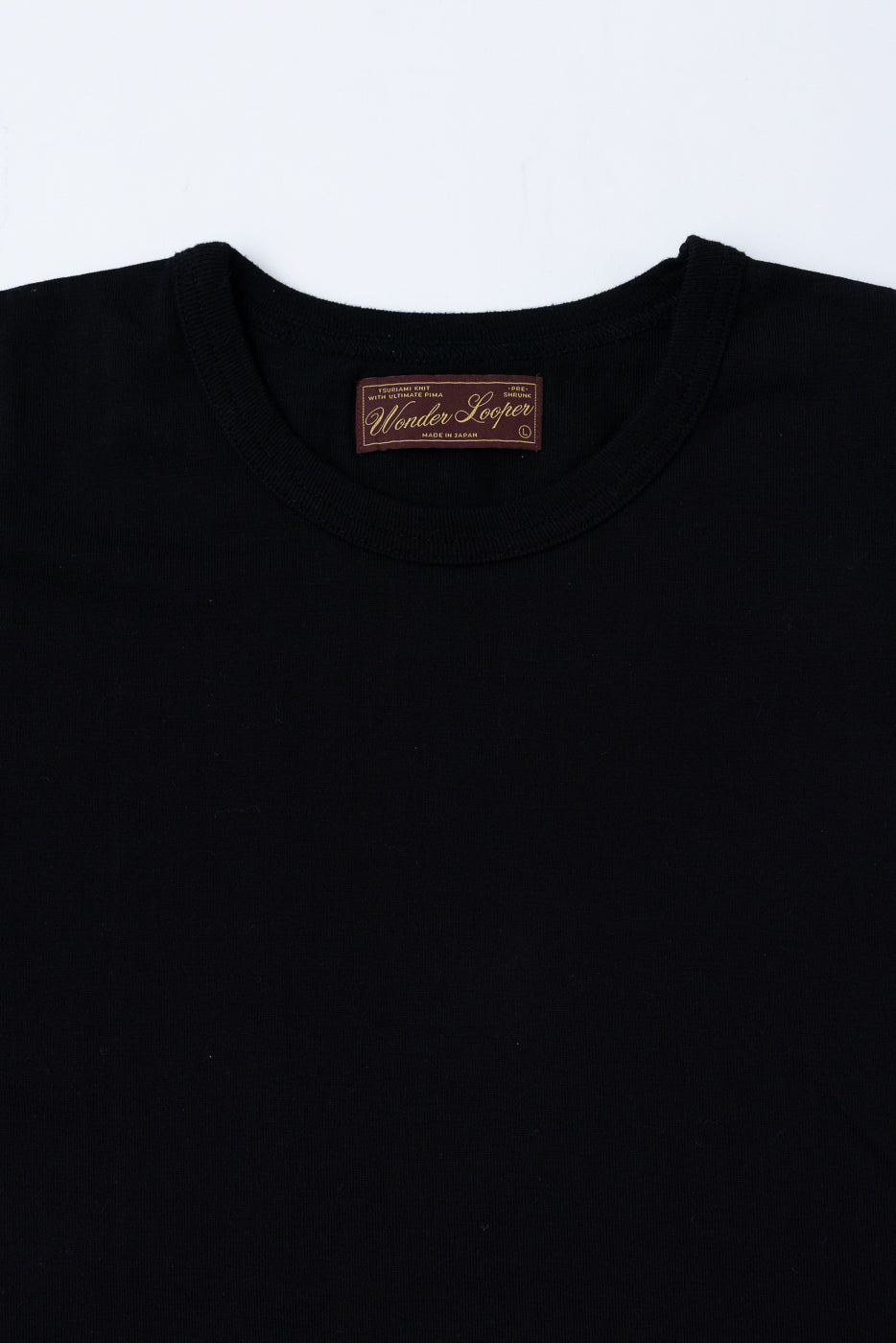 Close-up of the inner neck area showing the Wonder Looper brand tag on a black t-shirt.