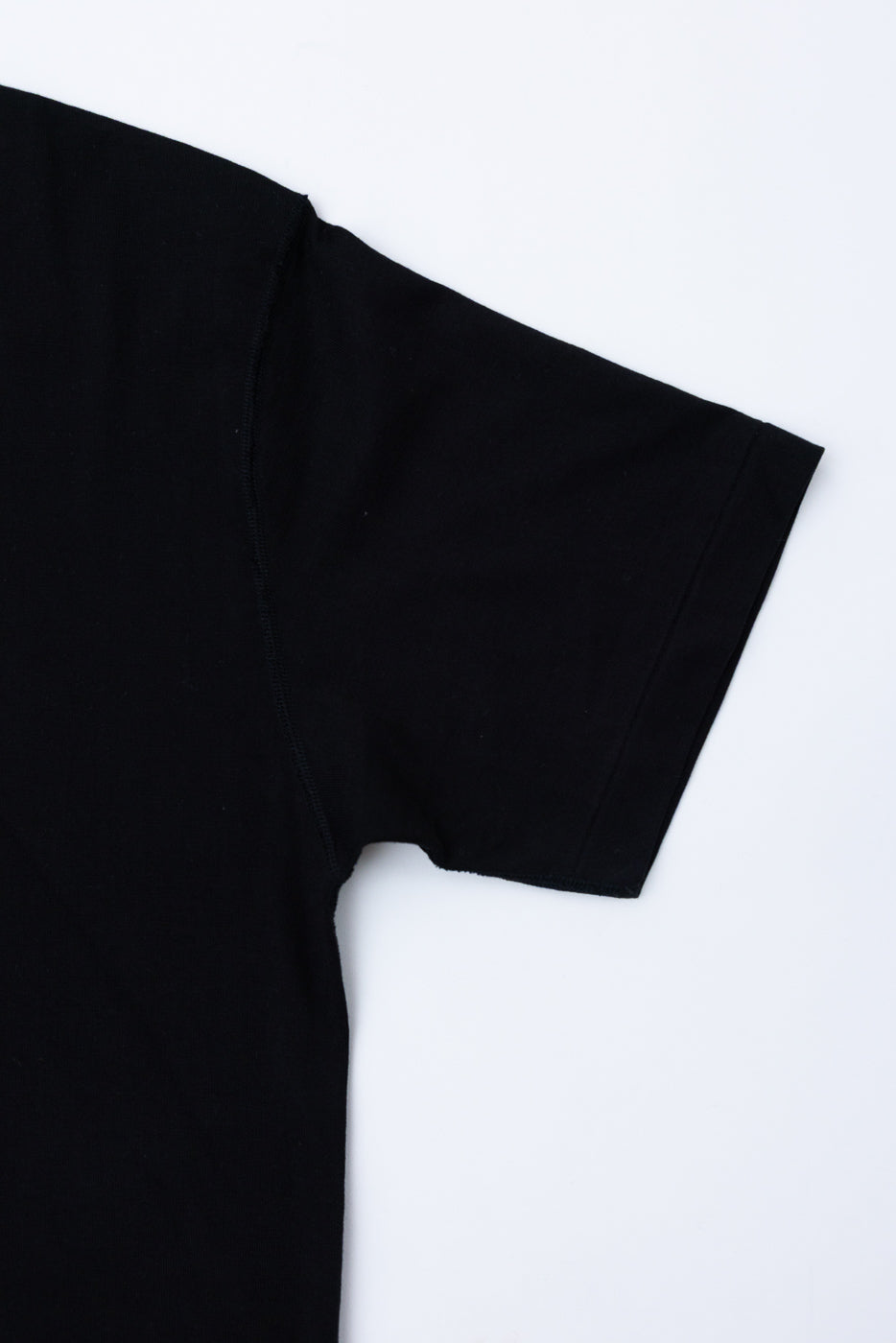 Close-up of the front right sleeve of a black short-sleeve t-shirt.