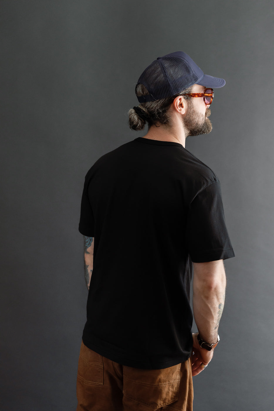 Back view of a black t-shirt on a male model (5'9