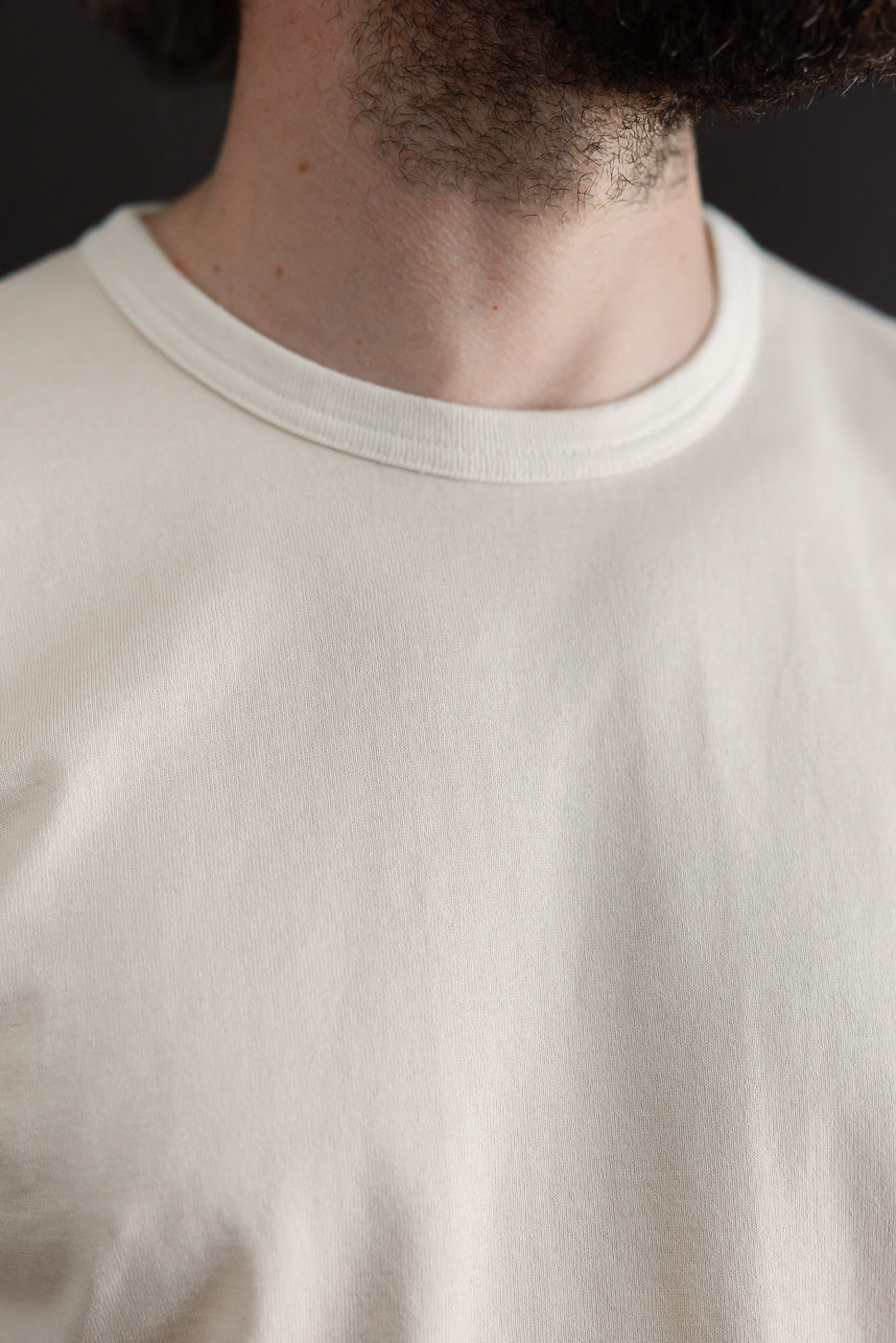 Close-up of the front crew neck collar on a male model, 5'9