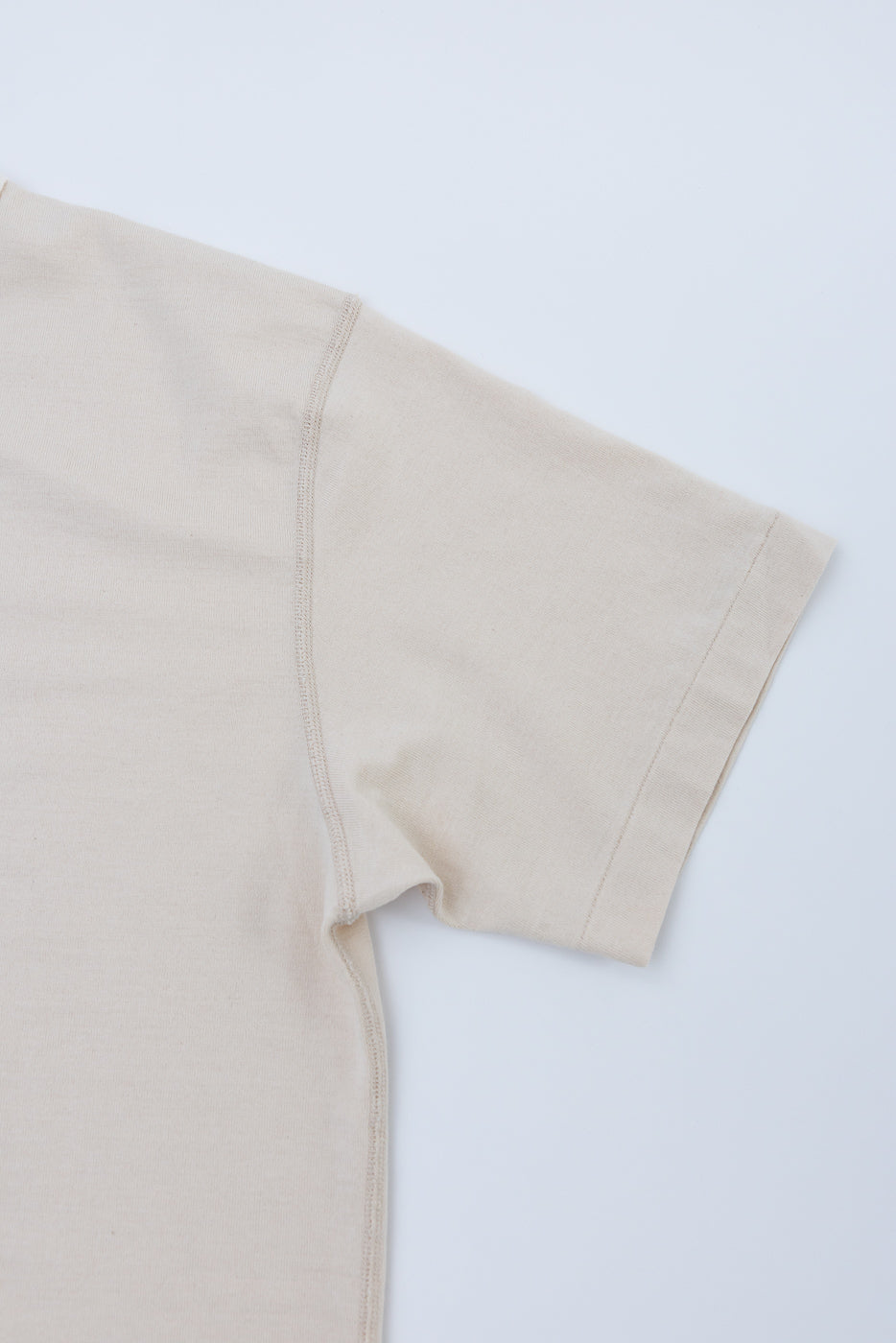 Ultimate Pima Tsuriami Crewneck T-Shirt - Ecru features a smooth, light beige fabric with visible shoulder seam and sleeve hem, showcasing its fine organic Pima cotton craftsmanship. Laid flat for detail.