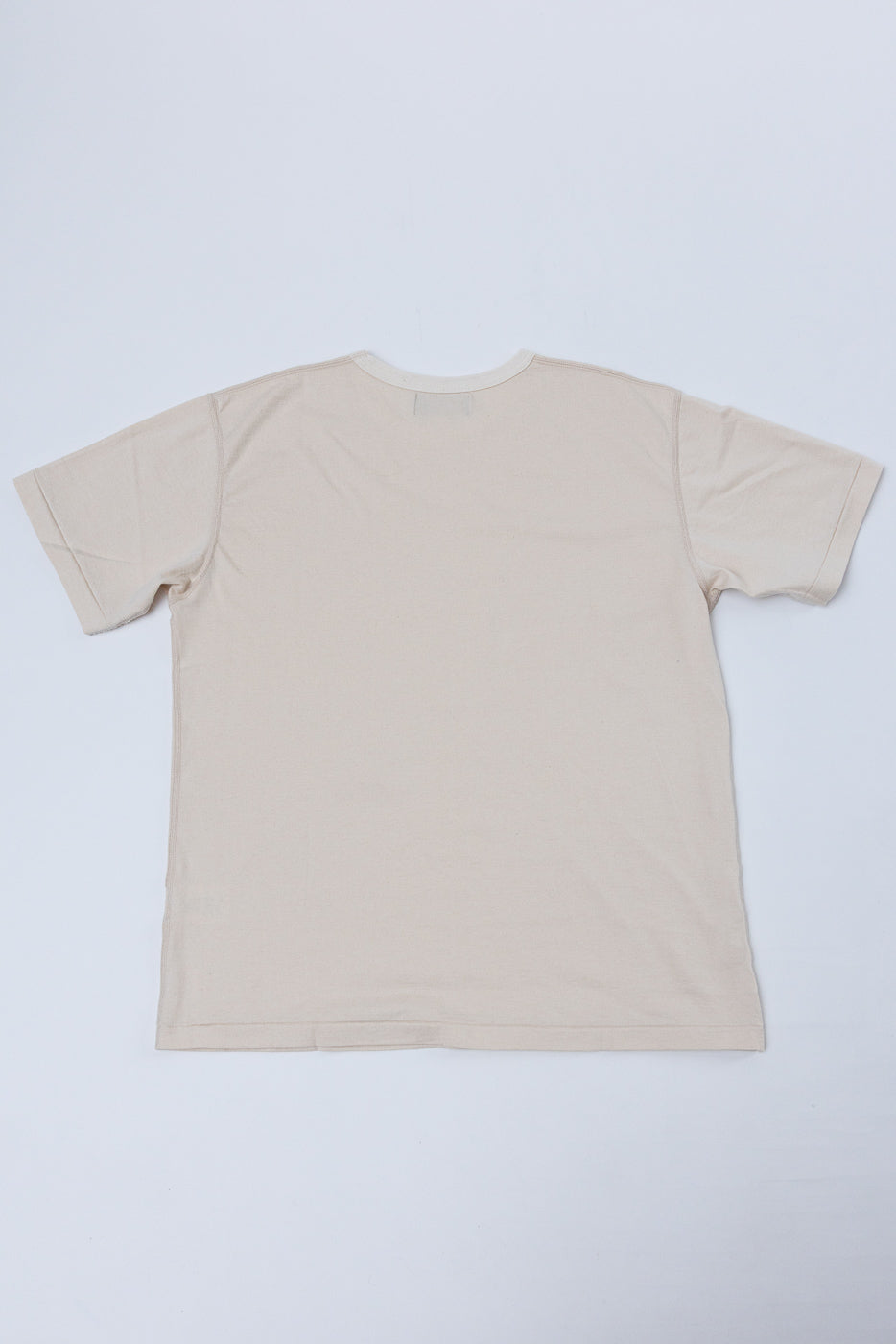 Back view of a plain cream-colored crew neck t-shirt flat lay.