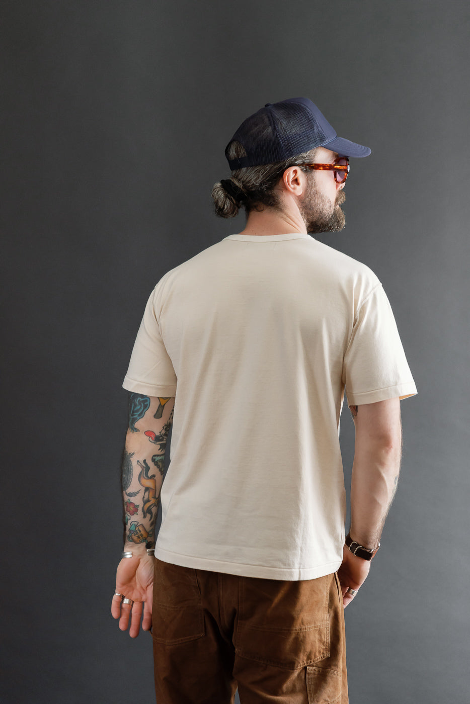 Back view of cream t-shirt on male model, 5'9