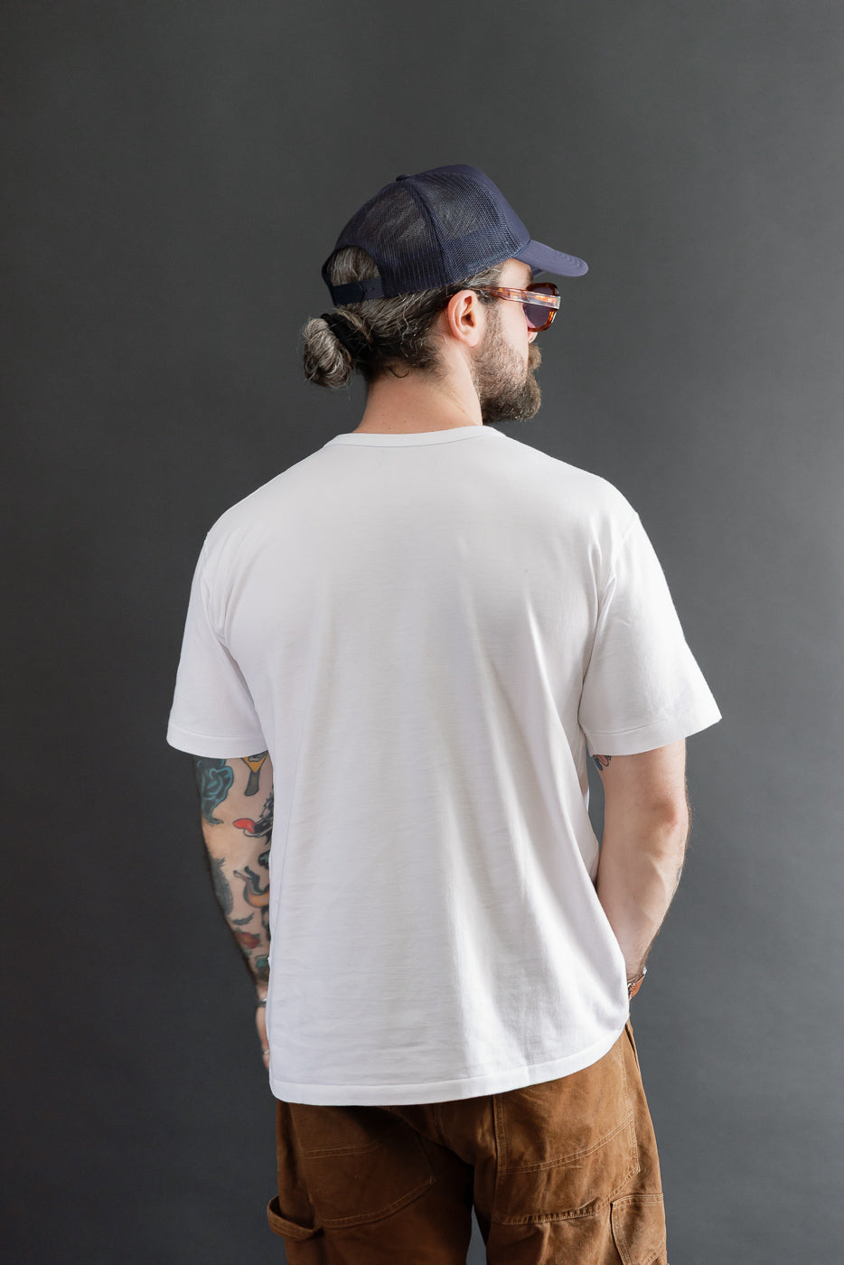 Back view of a white t-shirt on a male model, 5'9
