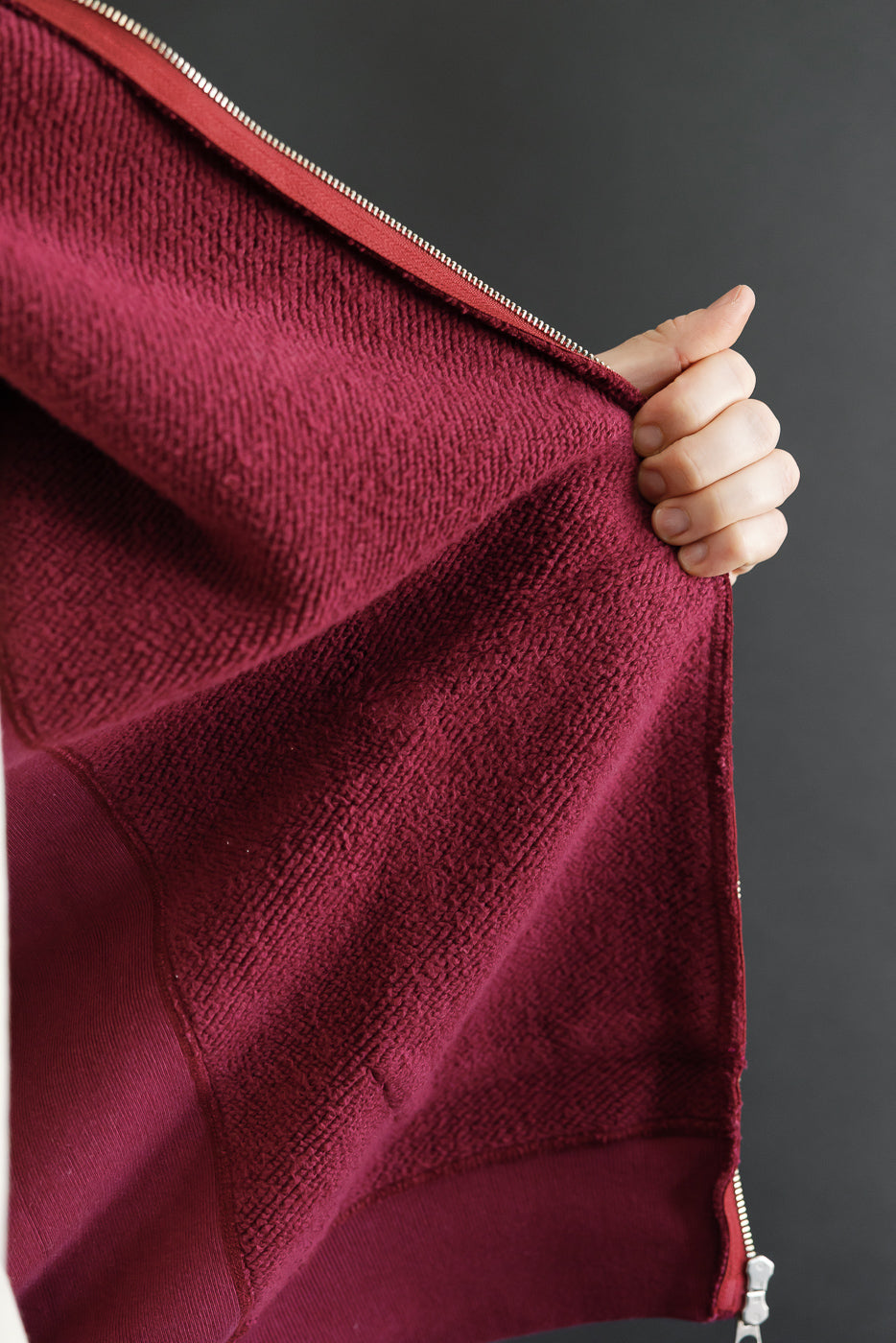 Close-up of the inner burgundy terry cloth fabric texture and zipper detail.