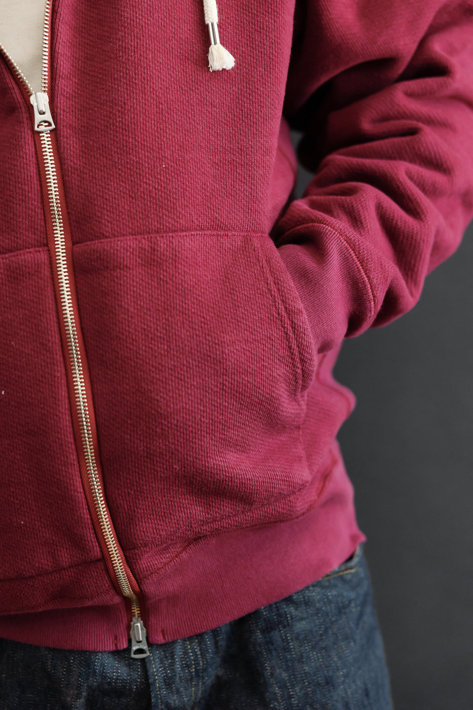 Close-up front view of a burgundy ribbed zip-up hoodie on a 5'9
