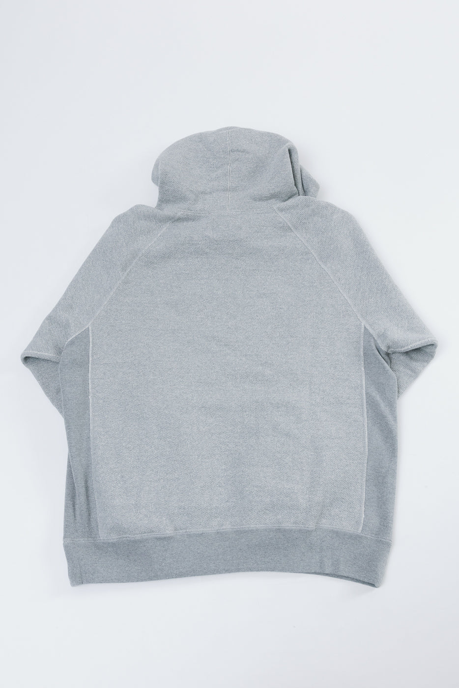 Flat lay back view of a grey hooded sweatshirt showing the hood and raglan sleeves.