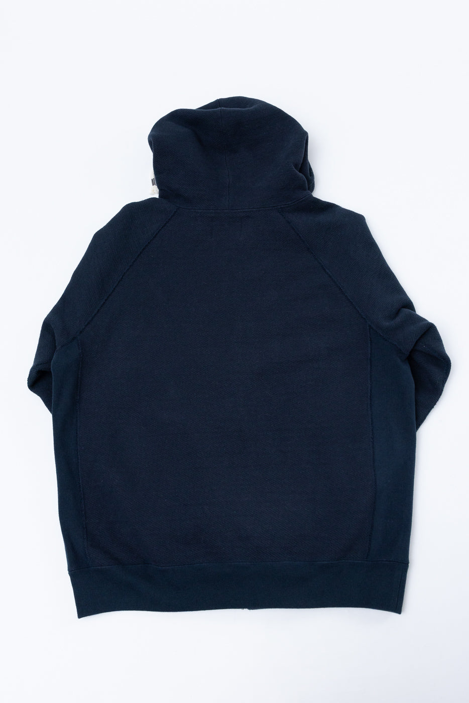 Flat lay, back view of a navy blue hooded sweatshirt showing the hood and raglan sleeves.