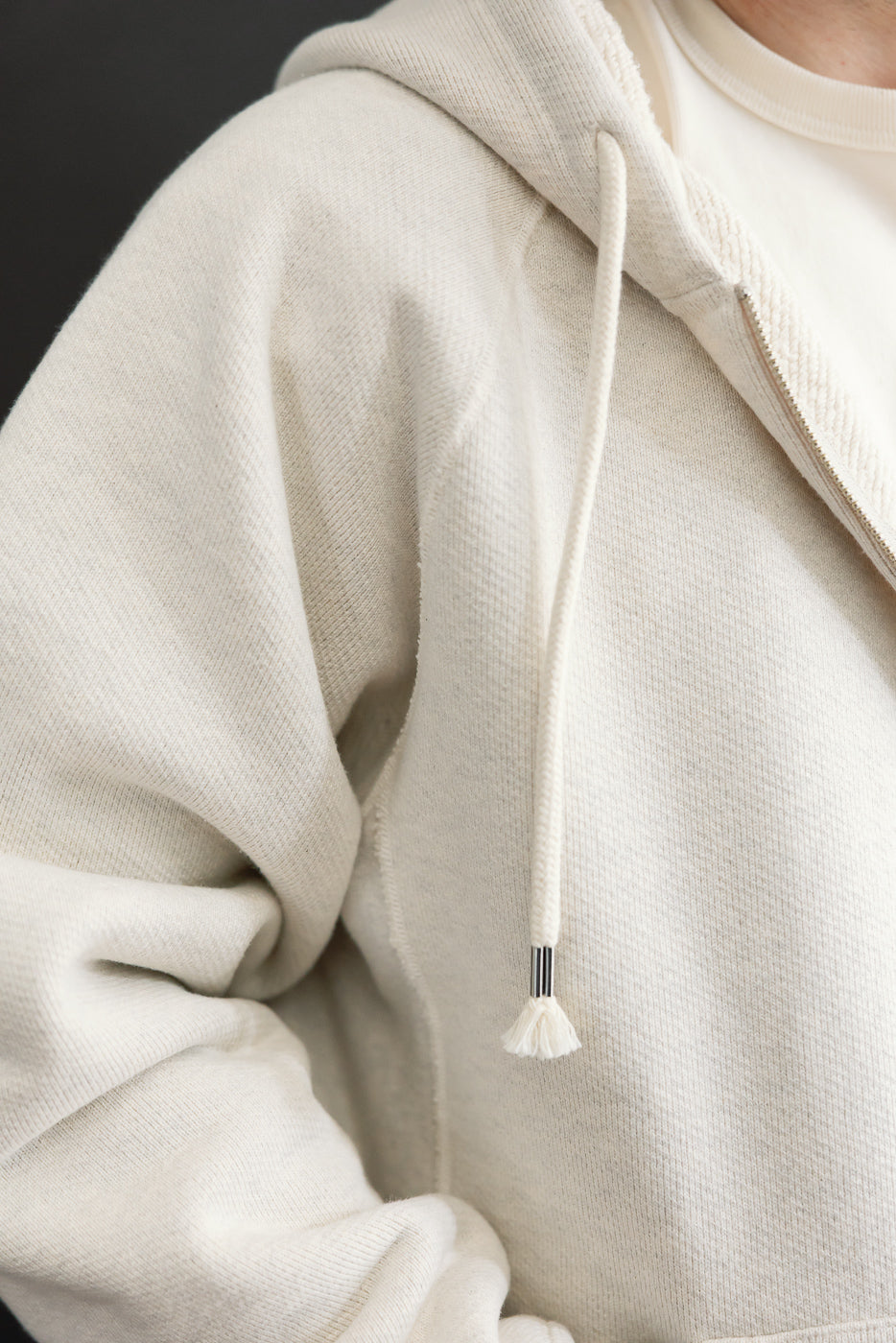 Close-up of the front right side of an off-white hoodie on a male model, 5'9