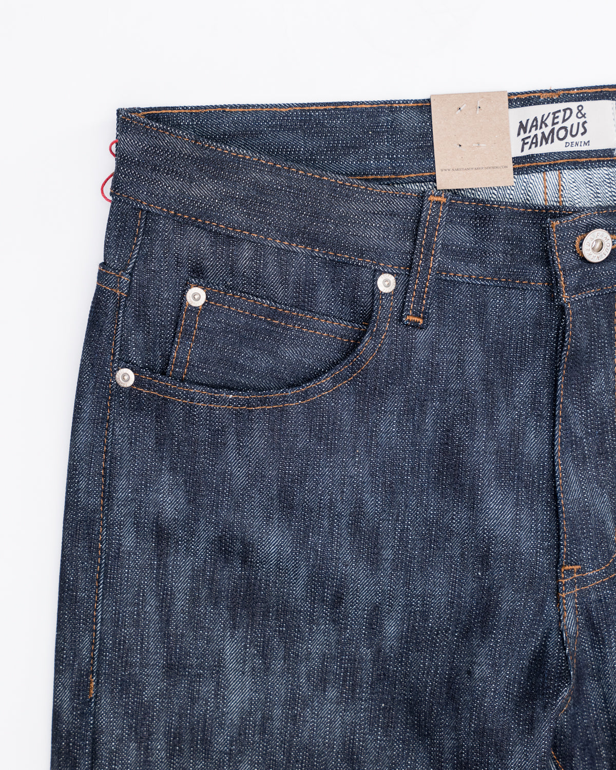 Close-up of front left hip and pocket on Naked & Famous 18oz Big Slub Selvedge jeans, showing button, rivet, belt loop, and denim texture.