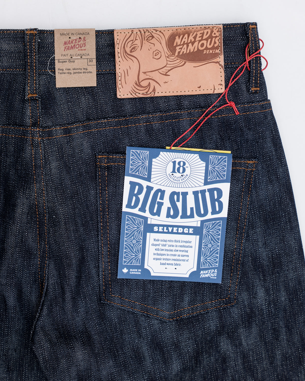 Close-up of Naked & Famous 18oz Big Slub Selvedge jeans, back side, leather patch, and rear pocket tag details.